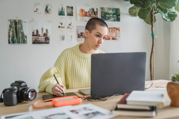  Creative entrepreneur sat working, looking at her laptop